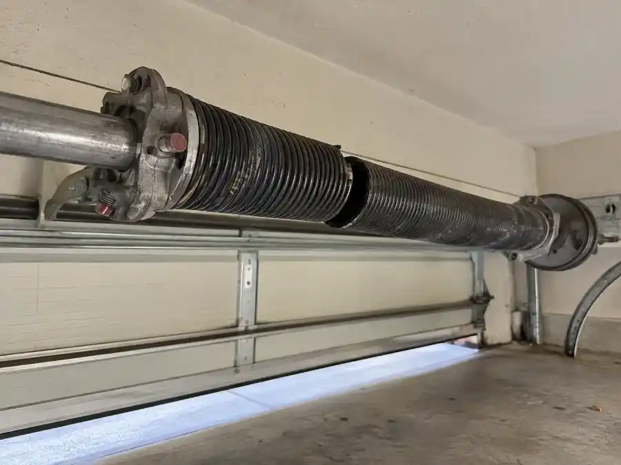 Garage Door Spring Repair & Replacement — Palm Coast, FL 1 Broken garage door torsion spring on a residential garage door in Palm Coast, FL — Palm Coast Garage Door Co.