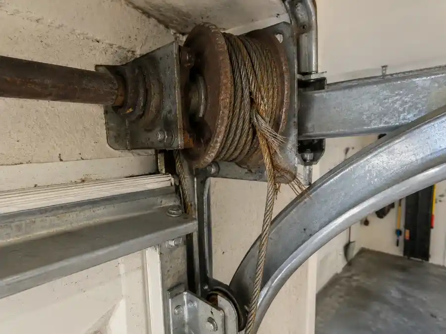 Garage Door Cable Repair & Replacement in Palm Coast, FL 1 Frayed and corroded garage door lift cable on a cable drum in a Palm Coast FL residential garage