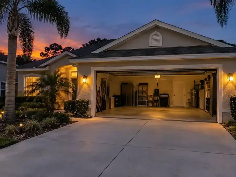 Garage door stuck open on a Palm Coast Florida home at dusk, showing security vulnerability

