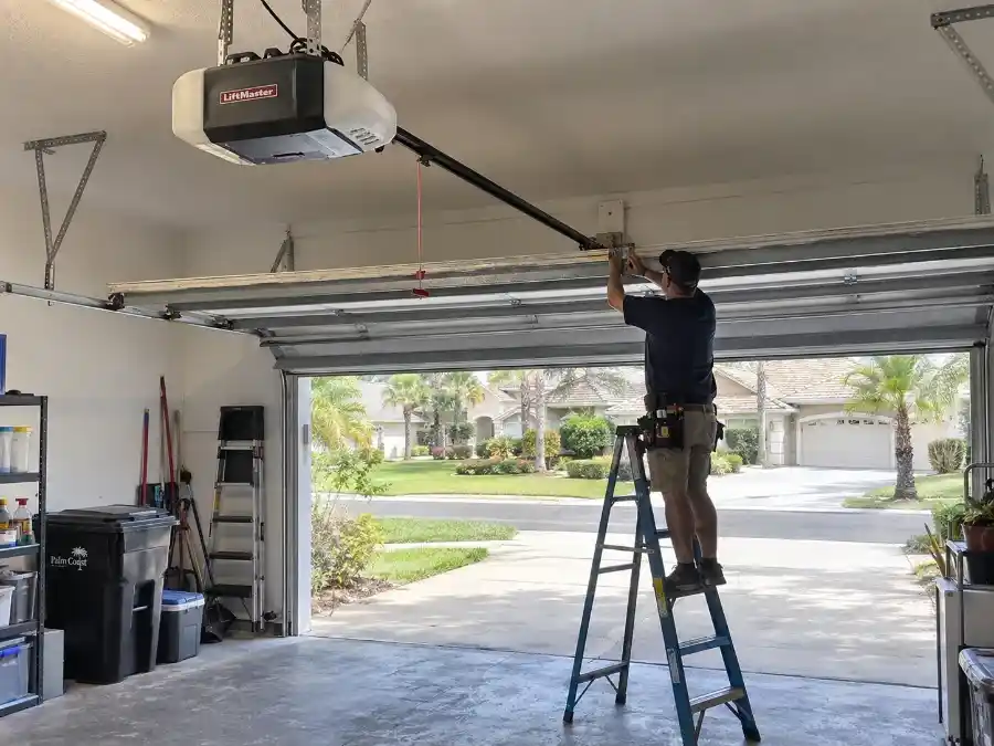 Garage Door Opener Repair & Installation in Palm Coast, FL 4 Palm Coast Garage Door Co. technician installing a LiftMaster belt-drive garage door opener in a residential garage in Palm Coast, Florida