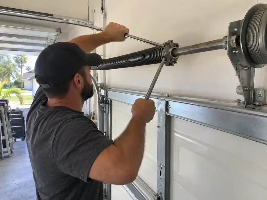 Garage Door Spring Repair & Replacement — Palm Coast, FL 3 Palm Coast Garage Door Co. technician using winding bars to replace a garage door torsion spring in Palm Coast, FL